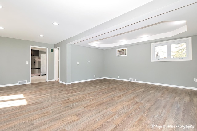 unfurnished room with baseboards, light wood-style flooring, and visible vents