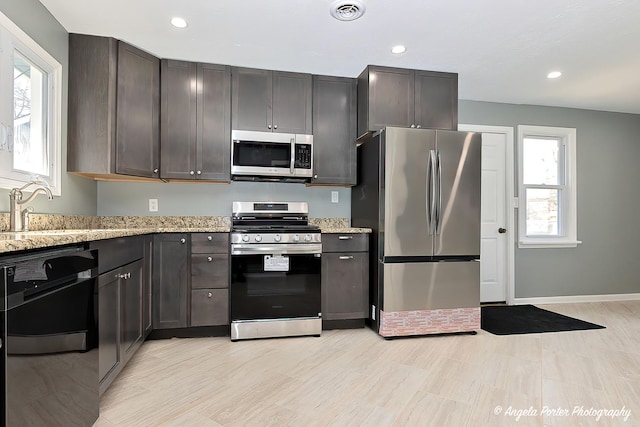 kitchen featuring visible vents, light stone countertops, recessed lighting, a sink, and stainless steel appliances