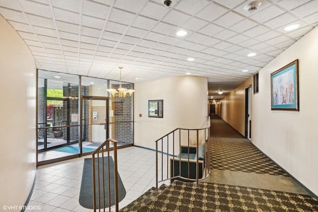 898 Wellington Ave Unit 310, Elk Grove Village, IL 60007 - hall featuring expansive windows, a chandelier, a paneled ceiling, and tile patterned floors
