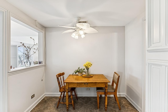 dining space with baseboards and a ceiling fan