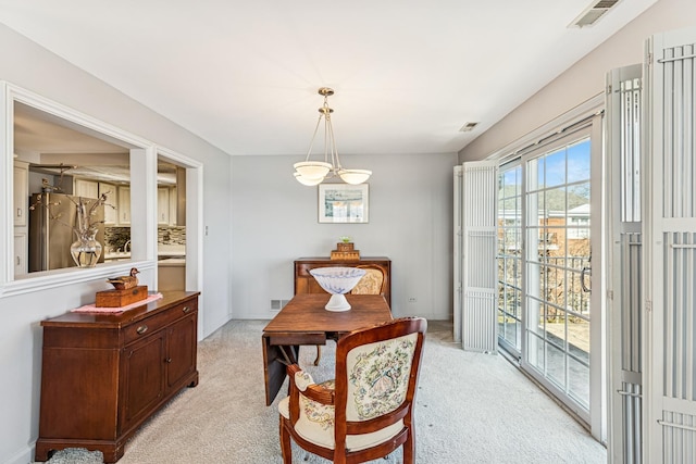 dining space with visible vents and light carpet
