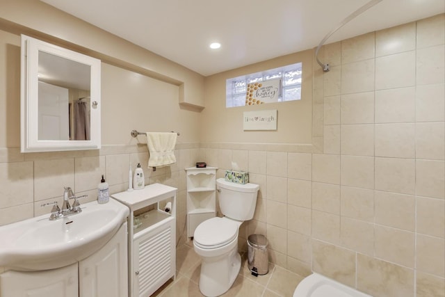 bathroom featuring vanity, toilet, tile patterned flooring, and tile walls