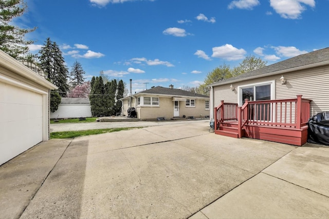 back of house with a wooden deck and a patio area