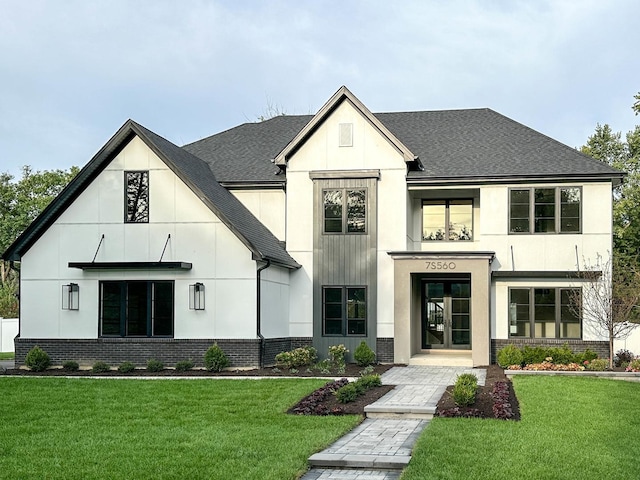 view of front of house featuring french doors, brick siding, a front yard, and roof with shingles