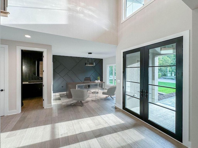 interior space with french doors, wood finished floors, and plenty of natural light