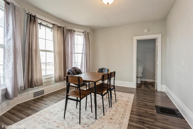 dining space featuring baseboards, dark wood-style flooring, and visible vents