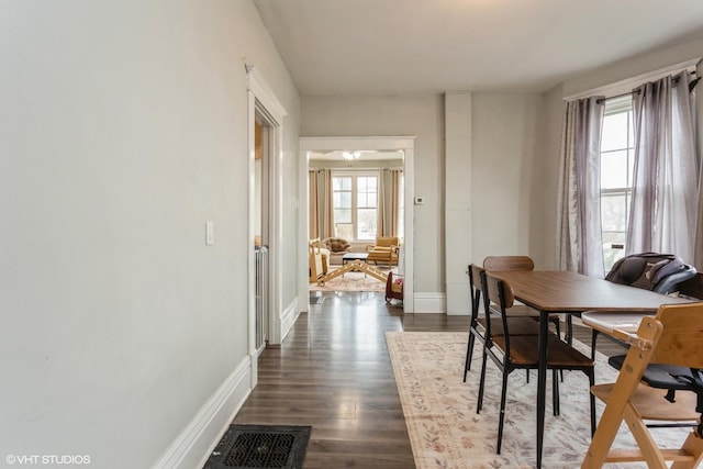 dining room featuring baseboards, visible vents, and dark wood-style floors