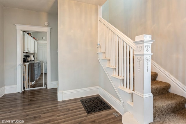 stairs with visible vents, baseboards, and wood finished floors