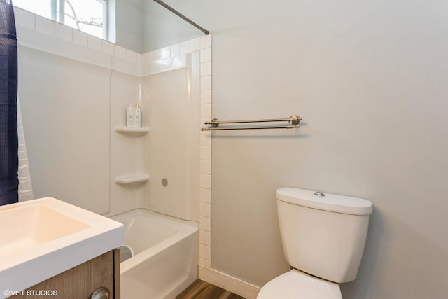 full bath featuring shower / bath combo, toilet, baseboards, wood finished floors, and vanity
