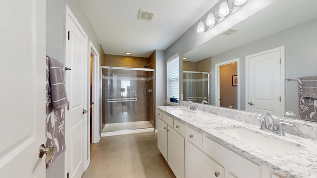 bathroom with a sink, a stall shower, double vanity, tile patterned flooring, and visible vents