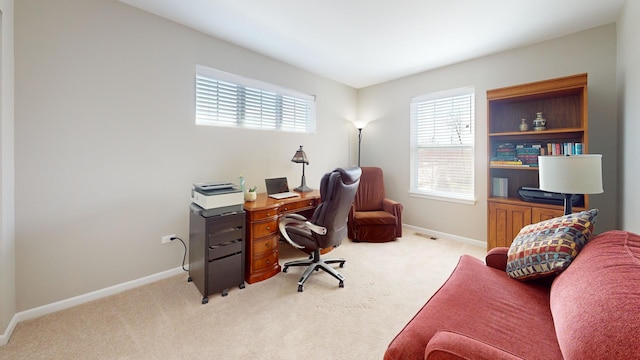 office space featuring baseboards, plenty of natural light, and light colored carpet