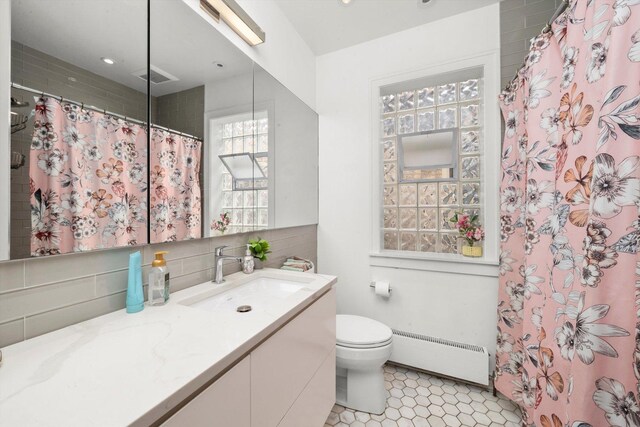full bathroom with tile patterned floors, a baseboard heating unit, decorative backsplash, vanity, and toilet
