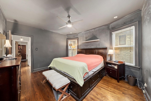 bedroom featuring baseboards, wood finished floors, ceiling fan, and crown molding