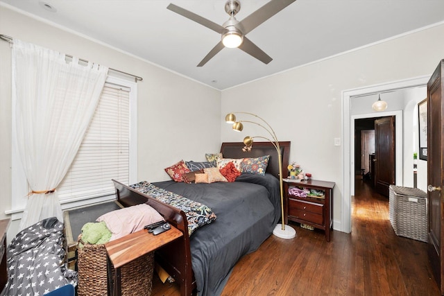 bedroom with baseboards, a ceiling fan, wood finished floors, and crown molding