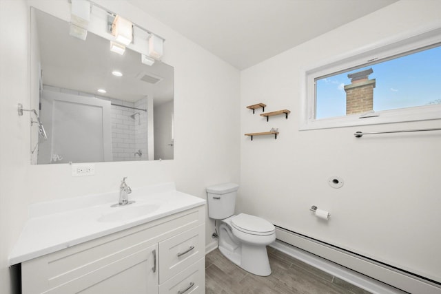 bathroom featuring baseboard heating, wood finished floors, vanity, a shower, and toilet
