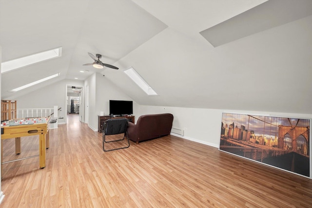 additional living space with light wood finished floors, a baseboard heating unit, lofted ceiling with skylight, baseboards, and a ceiling fan
