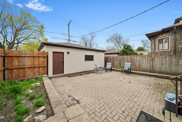 view of patio / terrace with a fenced backyard and an outbuilding