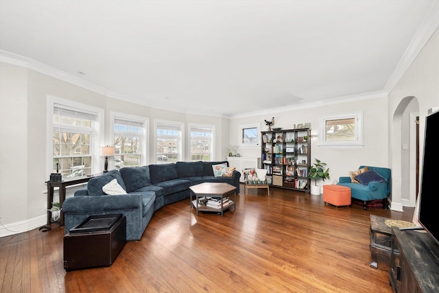 living area with baseboards, arched walkways, ornamental molding, and wood-type flooring