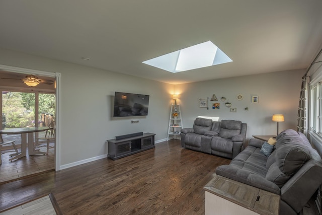 living area with baseboards, a skylight, and wood finished floors