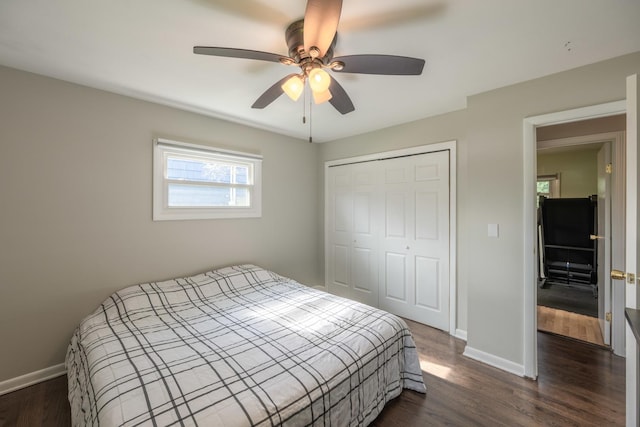 bedroom featuring dark wood finished floors, a closet, a ceiling fan, and baseboards