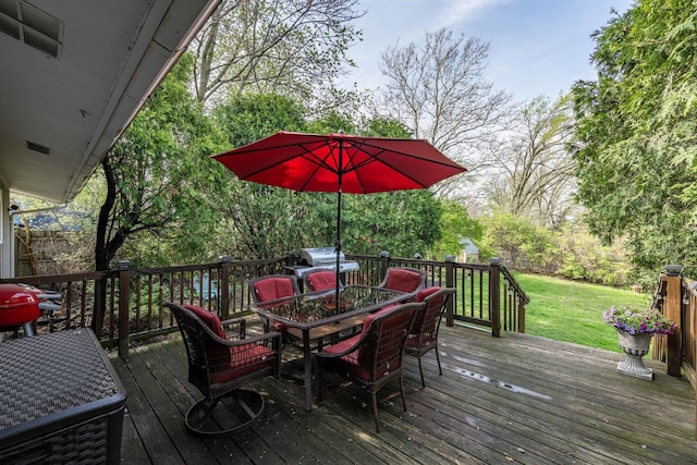deck with outdoor dining space and a lawn
