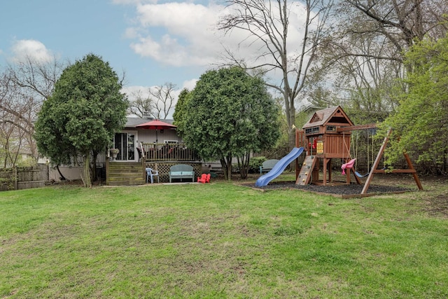 view of yard with fence, a deck, and a playground