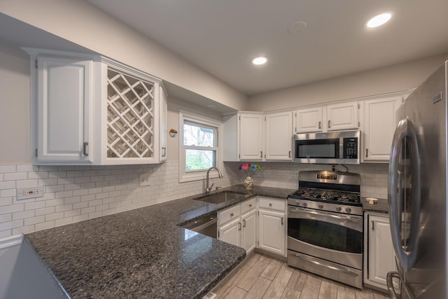 kitchen featuring a sink, white cabinets, stainless steel appliances, and tasteful backsplash
