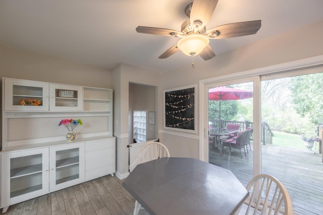 dining space featuring baseboards, light wood-type flooring, and ceiling fan