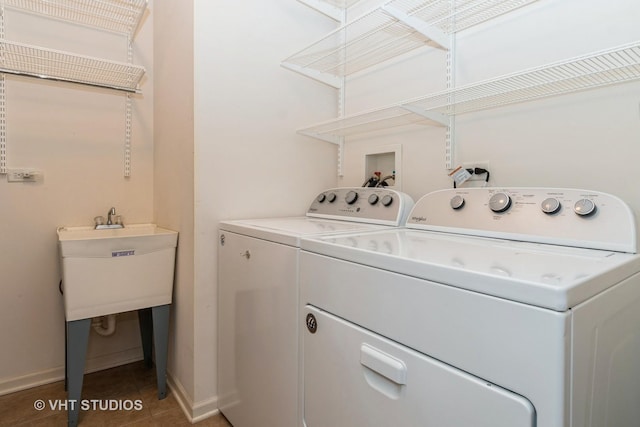 clothes washing area with baseboards, tile patterned floors, washer and clothes dryer, and laundry area