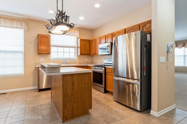 kitchen with a center island, a healthy amount of sunlight, stainless steel appliances, and light countertops