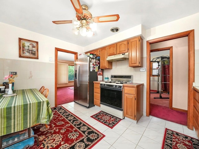 2758 N Newcastle Ave, Chicago, IL 60707 - kitchen with a ceiling fan, light tile patterned floors, stainless steel fridge with ice dispenser, under cabinet range hood, and gas range gas stove