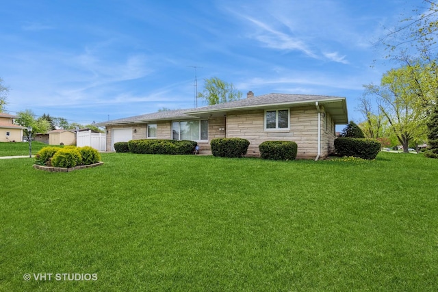 single story home featuring a front yard, an attached garage, and stone siding