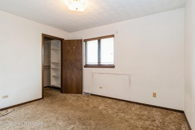 unfurnished bedroom with baseboards, carpet, visible vents, and a closet
