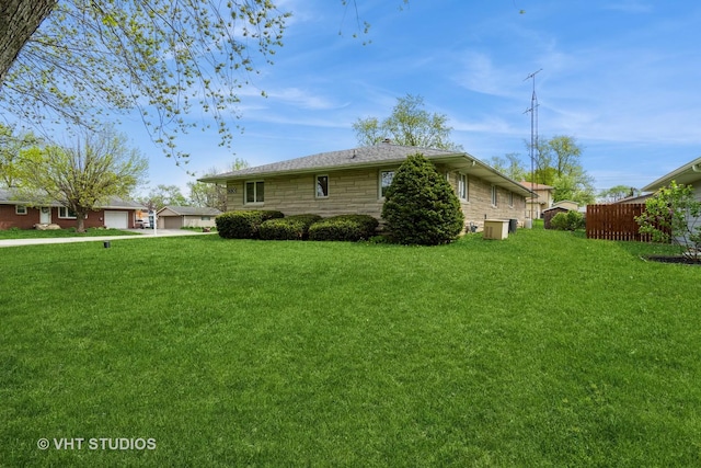 view of side of property featuring a lawn, cooling unit, a garage, and stone siding