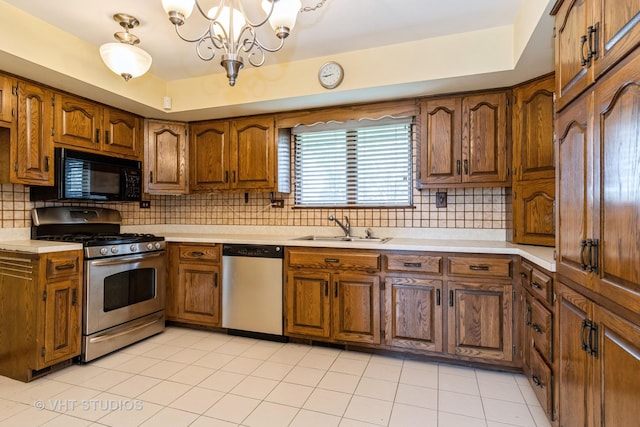 kitchen with a sink, appliances with stainless steel finishes, brown cabinets, and light countertops