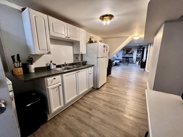 7971 S Kostner Ave, Chicago, IL 60652 - kitchen featuring light wood-style flooring, a sink, dark countertops, freestanding refrigerator, and white cabinetry