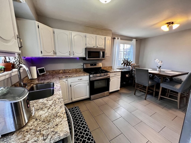7971 S Kostner Ave, Chicago, IL 60652 - kitchen with light stone counters, appliances with stainless steel finishes, a sink, and white cabinetry