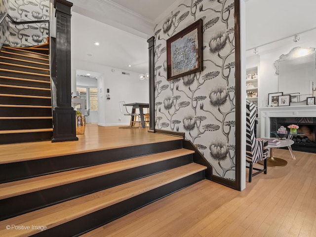 1343 N Sutton Pl, Chicago, IL 60610 - staircase featuring wood finished floors, ornamental molding, a fireplace, and recessed lighting