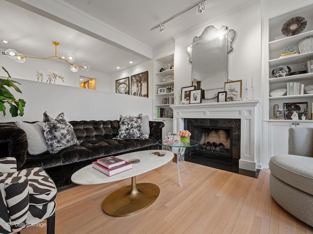 1343 N Sutton Pl, Chicago, IL 60610 - living room with built in shelves, wood-type flooring, a fireplace, crown molding, and rail lighting