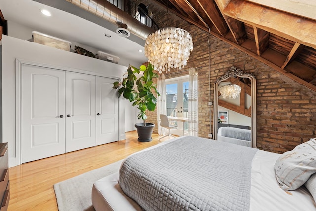 1547 N Leavitt St Unit 3S, Chicago, IL 60622 - bedroom with a notable chandelier, wood finished floors, a closet, brick wall, and access to outside
