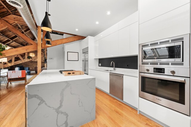 1547 N Leavitt St Unit 3S, Chicago, IL 60622 - kitchen featuring white cabinets, a kitchen island, built in appliances, and modern cabinets