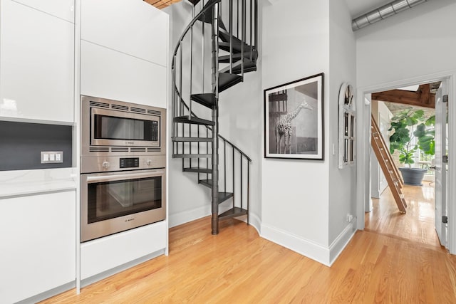 1547 N Leavitt St Unit 3S, Chicago, IL 60622 - kitchen with white cabinets, baseboards, appliances with stainless steel finishes, and light wood-style flooring