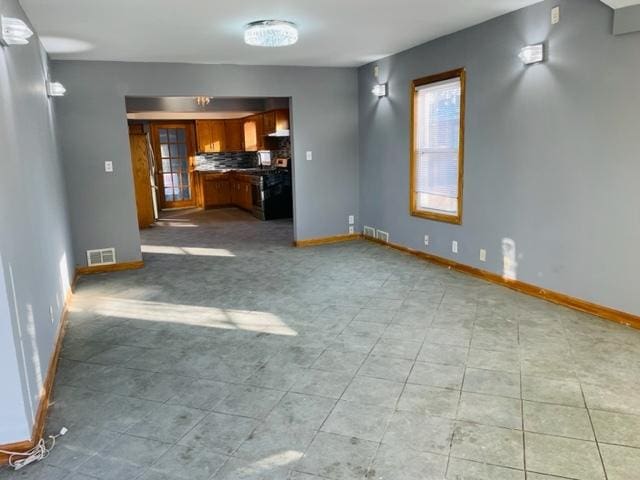 1218 Highland Ave, Joliet, IL 60435 - unfurnished living room with baseboards, visible vents, and light tile patterned floors