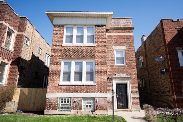 view of front of home with brick siding and fence
