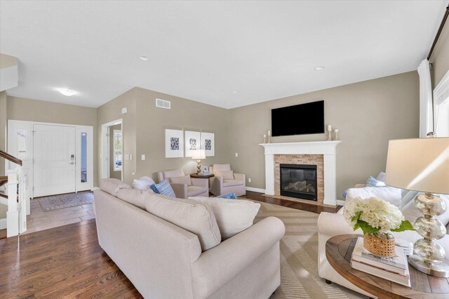living area with visible vents, recessed lighting, dark wood-type flooring, and a fireplace