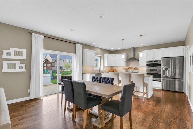 dining room with dark wood-style flooring, baseboards, and recessed lighting