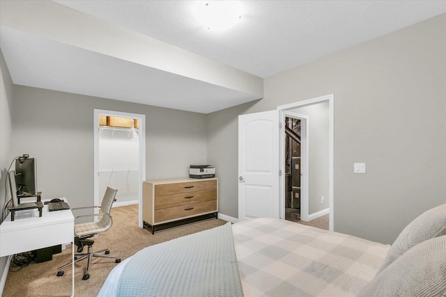 bedroom with baseboards, light colored carpet, a spacious closet, and a closet