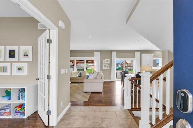foyer with baseboards, stairs, and visible vents
