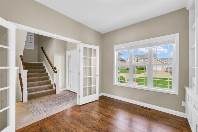 interior space featuring visible vents, baseboards, stairway, french doors, and dark wood finished floors