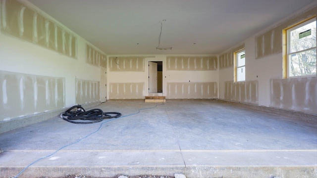 unfurnished room with unfinished concrete flooring